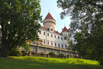 The medieval Konopiste Castle in Czech Republic high up, sunny summer day, blue sky between the trees, european park