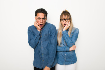 Young couple with glasses surprised and shocked while looking right