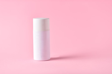 white cosmetic jar on pink background