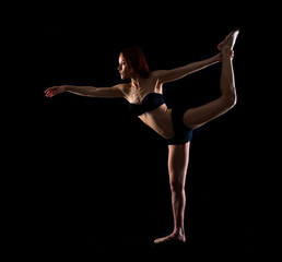 Fototapeta na wymiar Redhead Girl doing yoga in studio