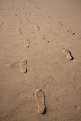 Fototapeta na wymiar Footprints with relief in the wet sand of the beach