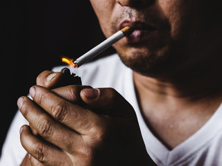 Fototapeta premium Man smoking cigarette.concepts of medical marijuana use and legalization of the cannabis. On a black background