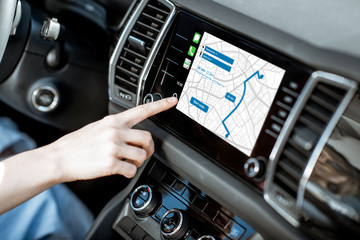 Touching a monitor with navigation map of the modern car, close-up view