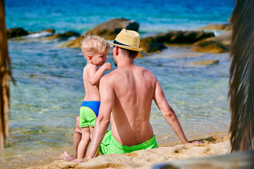 Toddler boy on beach with father