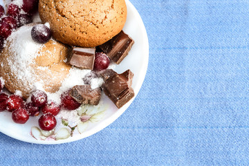 Oatmeal cookies with berries and chocolate on a plate - sweet still life
