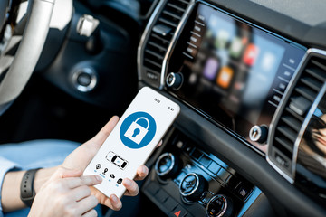 Close-up of a smart phone with car alarm application, controlling a vehicle in the car