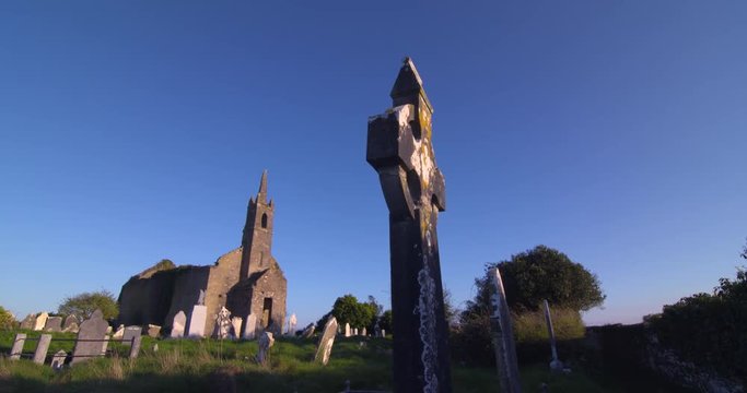 Country graveyard cemetery celtic cross ruined church summer sunshine