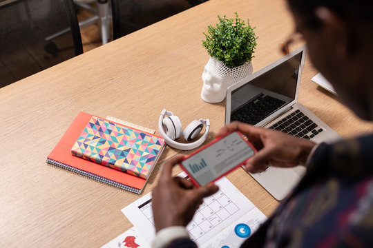 Man checking the information on paper with his smartphone