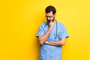 Surgeon doctor man looking down with the hand on the chin