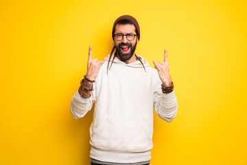 Hippie man with dreadlocks making rock gesture