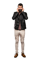 Handsome man with beard frustrated and covering ears over isolated white background