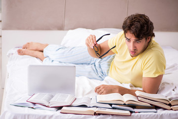 Obraz premium Young student studying in bed for exams