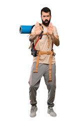 Hiker man making stop gesture and disappointed over isolated white background