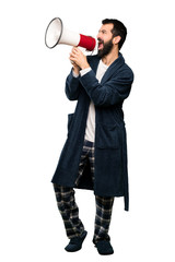 Man with beard in pajamas shouting through a megaphone over isolated white background