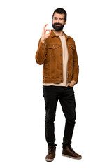 Fototapeta premium Handsome man with beard showing ok sign with fingers over isolated white background