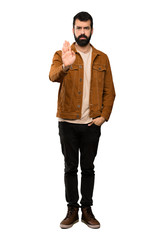 Handsome man with beard making stop gesture over isolated white background