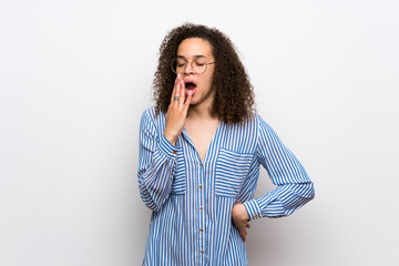 Dominican woman with striped shirt yawning and covering wide open mouth with hand