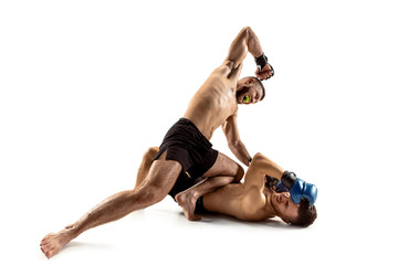 MMA. Two professional fightesr punching or boxing isolated on white studio background. Couple of fit muscular caucasian athletes or boxers fighting. Sport, competition, excitement and human emotions