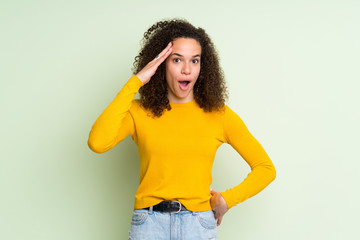 Dominican woman over isolated green background has just realized something and has intending the...