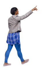 Side view of a young black girl in jeans and a checkered shirt.