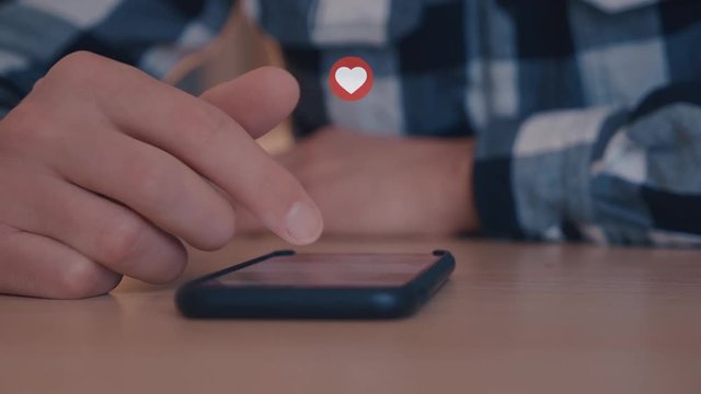 A man scrolls through social networks and clicks on heart likes on posts
