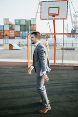 Men in suits play basketball on the sports field to advertise men's clothing. Shooting for men's clothing store