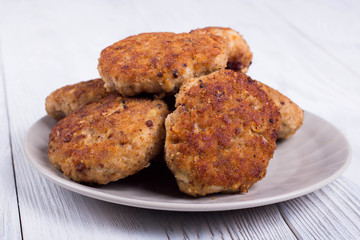 cutlets on a grey plate, on a white wooden background