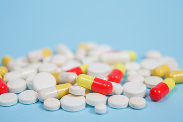 Pills are scattered over a blue background