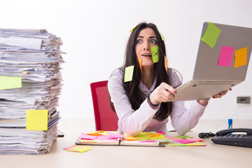 Young female employee in conflicting priorities concept