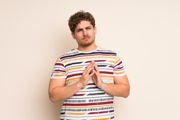 Blonde man over isolated wall scheming something