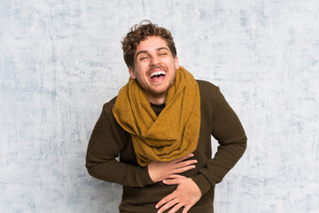 Blonde man over grunge wall smiling a lot