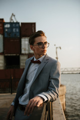 A man in a gray suit poses on the street to advertise men's clothing. Shooting for men's clothing store