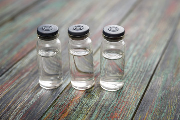 Injection bottle on wooden background