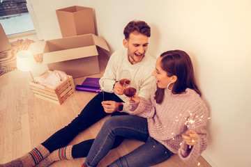 Couple sitting on the floor while celebrating moving in new apartment