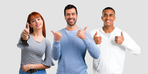 Group of three friends giving a thumbs up gesture and smiling