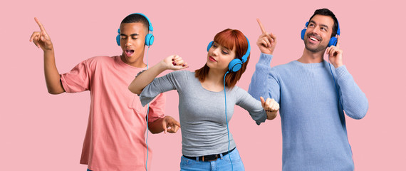 Group of three friends listening to music with headphones - Powered by Adobe