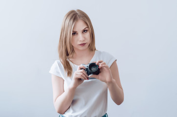 Fototapeta premium Attractive girl holding a vintage camera in her hands