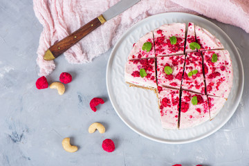 Vegan raw raspberry nut cheesecake on a light  background. Healthy vegan food concept.  Sugar, dairy and gluten free dessert