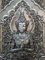 Fototapeta na wymiar Traditional Thai Hand Carved Silver Panel with the Guardian Angel on the Temple Wall