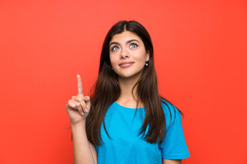 Teenager girl with blue shirt pointing with the index finger a great idea