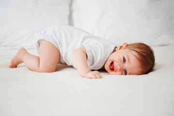 Playful baby having fun in bed