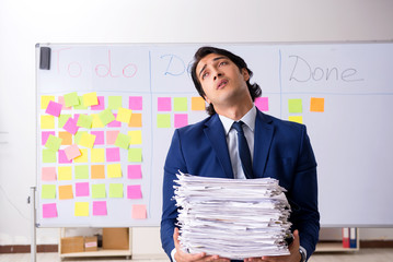 Young handsome employee in front of whiteboard with to-do list