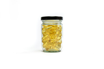 Fish oil capsules in jar glass isolated on white background. Omega 3. Vitamin E. Supplement food background.