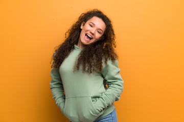 Happy Teenager girl over ocher wall.