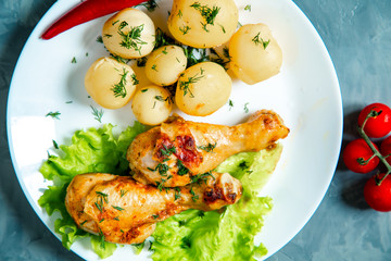 Chicken legs with potatoes and vegetables.