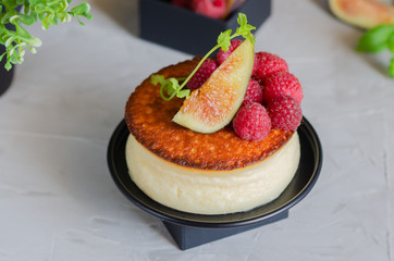 Creamy New York style Cheesecake with berry topping. Example of elegant foodstyling with fruits, fig, raspberry and mint.