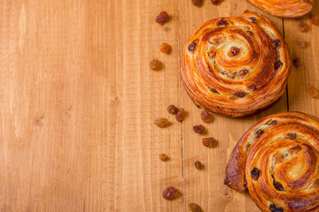 Fresh homemade pain au raisins croissant  over wooden background