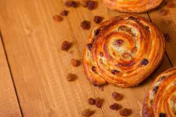 Fresh homemade pain au raisins croissant  over wooden background