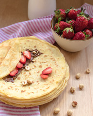 crepes with strawberries and chocolate cream, black background