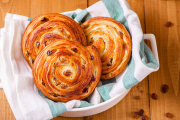 Fresh homemade pain au raisins croissant  over wooden background